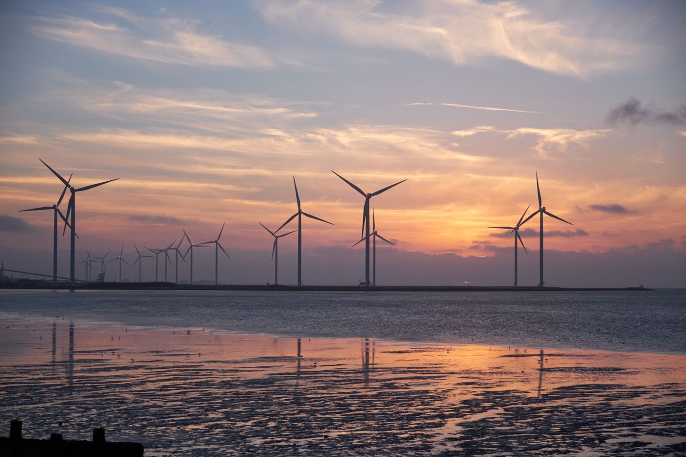 Wind turbines at sunset over water